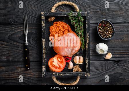 Mallorcan Sobrassada salumi di carne di maiale in un vassoio di legno sfondo di legno nero. Vista dall'alto Foto Stock