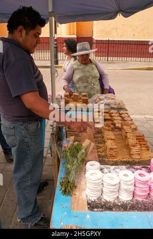 Donna anziana che acquista prodotti da forno messicani da un venditore ambulante a Cholula, Puebla, Messico Foto Stock