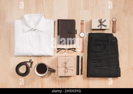 Hand watch, shirt, coffee cup, notebook and male accessories on wooden background floor backround. Stock Photo
