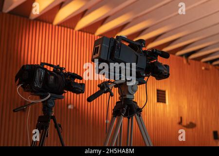 Due videocamere per lo streaming live o la produzione video in un evento di gala. Due telecamere sui cavalletti di un evento. Foto Stock