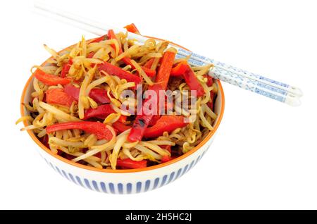 Ciotola di germogli di fagioli fritti e peperoni rossi isolati su sfondo bianco Foto Stock
