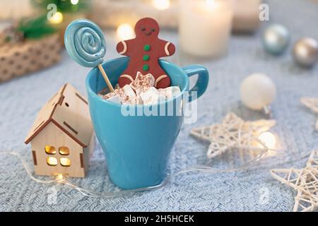 Tazza blu con marshmallows di cacao, lecca e pan di zenzero al cioccolato Foto Stock