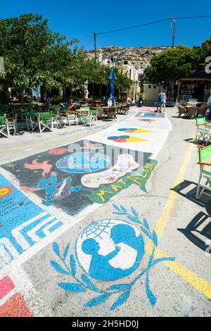 Disegni artistici di cultura hippy sulla pace e l'amore dipinte sul marciapiede di piazza Matala, Creta, Grecia Foto Stock