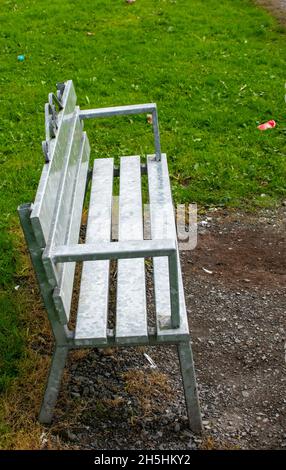 Molti colori (rosso, blu, verde, giallo, metallo) panchine di legno vuote nel parco per il riposo romantico durante la passeggiata, Irlanda, Europa Foto Stock