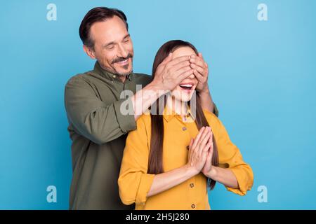 Foto di attraente signora bel ragazzo mani che coprono gli occhi hanno buon umore isolato su sfondo blu Foto Stock