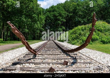 Westerbork, Paesi Bassi-luglio 2021; vista ad angolo basso della rotta della ferrovia strappata da terra come monumento per la deportazione di ebrei e zingari Foto Stock