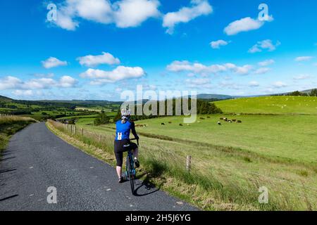 Motociclista femminile al suo primo giro con una bici elettrica da strada, Bowland, Lancashire, Regno Unito. Foto Stock
