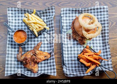 Sheffield UK – 01 maggio 2018: Pollo fritto, hamburger di maiale, patatine fritte, patatine fritte e anelli di cipolla – cibo americano al barbecue da Fire Pit Foto Stock