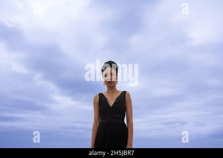 Donna con colpo di copricapo contro il cielo limpido Foto Stock