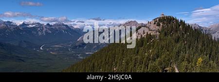 Vista della vetta della Sulphur Mountain con passerella in legno tra gli alberi nel Banff National Park, Alberta, Canada, con panorama delle aspre Montagne Rocciose. Foto Stock