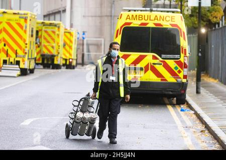 Londra, Regno Unito. 10 Ott 2021. Linee di ambulanze e personale NHS fuori dal Royal London Hospital a Whitechapel. Il Segretario della Sanità, Sajid Javid, ha annunciato il 9 novembre che le vaccinazioni di Covid saranno obbligatorie per il personale NHS. C'è la preoccupazione che l'NHS possa perdere migliaia di persone che si rifiuteranno di ottenere il vaccino. Potrebbe esserci un impatto significativo sulla forza lavoro che è già molto tesa. L'Organizzazione Mondiale della Sanità ha criticato Boris Johnson per non aver indossato una maschera in un ospedale. Credit: Mark Thomas/Alamy Live News Foto Stock