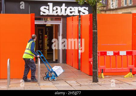 Negozio di abbigliamento Slaters gent; appaltatori di rivestimenti per costruzioni Topek Limited iniziano i lavori sulla Crystal House di Preston, la struttura meno amata della città. Il rivestimento dell'edificio, costruito sul sito dell'ex municipio, è stato modificato per aumentare la sicurezza antincendio. Nel periodo successivo al disastro di Grenfell, l'edificio a 12 piani è diventato il secondo alto edificio nel centro della città a far sostituire il suo rivestimento. Foto Stock