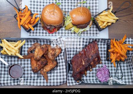 Sheffield UK – 22 maggio 2018: Costolette di ricambio per barbecue, pollo fritto, hamburger e patatine fritte - cibo barbecue americano da Fire Pit, West Street Foto Stock