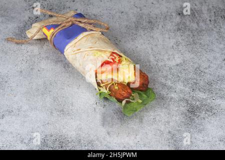 Involtino di pollo fresco con tomatos freschi, insalata, formaggio e cipolle isolate su sfondo blu chiaro. Messa a fuoco lato view.selective Foto Stock