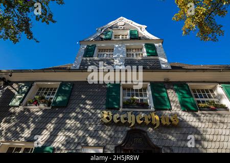 Germania, Haan, Bergisches Land, Niederbergisches Land, Niederberg, Renania settentrionale-Vestfalia, NRW, Becherhus nella Kaiserstrasse, casa a graticcio con facciata in ardesia, persiane verdi, Bergisches barocco, gastronomia, ristorante, autunnale Foto Stock