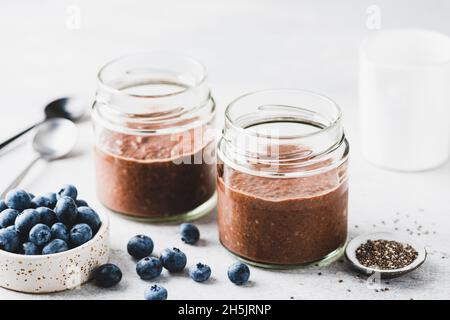 Budino di cioccolato chia in bicchiere servito con mirtilli freschi Foto Stock