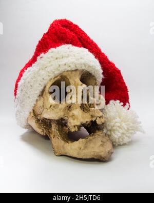 cranio umano con cappuccio di elfo isolato su sfondo nero Foto Stock