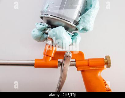 Pistola per schiuma da costruzione con cilindro difettoso. Difetto del flacone di schiuma Foto Stock