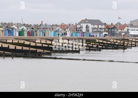 30 agosto 2021 - Essex, Regno Unito: Lungomare con capanne da spiaggia e frangiflutti in mare Foto Stock