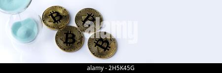 Oro bitcoin e clessidra su sfondo bianco. Una posizione per il testo per il disegno. Foto Stock