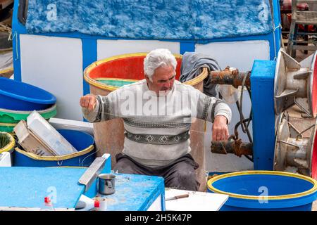 Heraklion, Grecia - 27 marzo 2018: Il pescatore fa il suo lavoro su una nave. Foto Stock