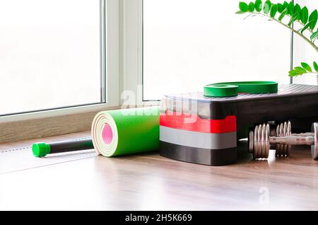 Set di inventario fitness sul pavimento vicino alla finestra. Spazio per il testo Foto Stock