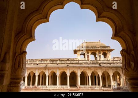 Vista ad arco sul passaggio pedonale colonnato e sul cortile interno nel Forte Ahhichatragarh (Forte Nagaur); Nagaur, Rajasthan, India Foto Stock