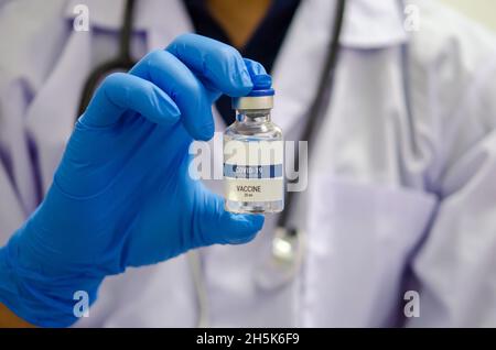 Medico o laborante che contiene una provetta per il vaccino COVID-19 o un vaccino per il coronavirus. Concetto di vaccino del coronavirus Foto Stock