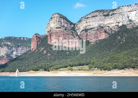 Sau Reservoir e la catena montuosa Las Guillerias con il campanile sommerso del villaggio di San Roman de Sau, Barcellona Foto Stock