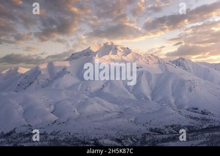 Tramonto sulle montagne innevate che trasformano la vista in un'opera d'arte, vicino a Sheep Mountain lungo la Glenn Highway Foto Stock