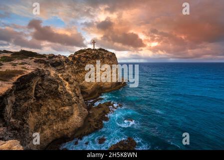 Grand-Croix in cima alla penisola rocciosa di Pointe des Chateaux con un suggestivo cielo nuvoloso, Grande-Terre; Guadalupa, Antille francesi Foto Stock