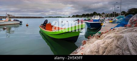 Barche a motore e da pesca ormeggiate al molo, accatastate con reti da pesca nel porto di Sainte Rose a basse-Terre; Guadalupa, Antille francesi Foto Stock