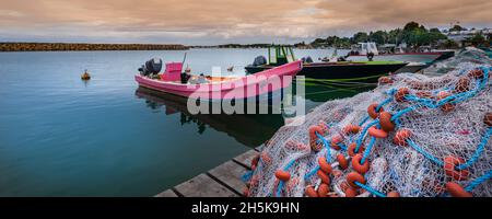 Barche a motore e da pesca ormeggiate al molo, accatastate con reti da pesca nel porto di Sainte Rose a basse-Terre; Guadalupa, Antille francesi Foto Stock