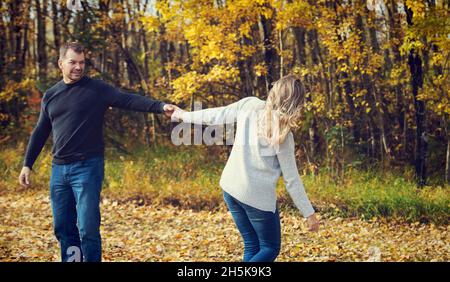 Una coppia sposata trascorre del tempo di qualità insieme e balla all'aperto in un parco cittadino durante la stagione autunnale; St. Albert, Alberta, Canada Foto Stock