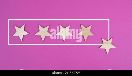 Cinque stelle su uno sfondo rosa, mano mettere l'ultima stella in fila, la valutazione, dando feedback Foto Stock