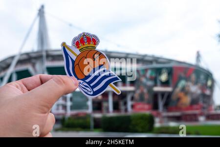 30 agosto 2021, San Sebastian, Spagna. L'emblema della squadra di calcio Real Sociedad sullo sfondo di uno stadio moderno. Foto Stock