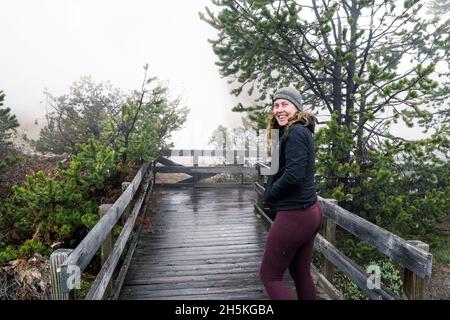 Una giovane donna cammina verso Beryl Springs nel Parco Nazionale di Yellowstone Foto Stock