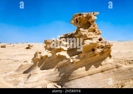 I resti fossili di dune di sabbia nel deserto vicino alla città di Abu Dhabi ad Abu Dhabi, Emirati Arabi Uniti. Le linee elettriche all'orizzonte sono state rimosse Foto Stock