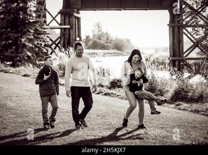 La famiglia trascorre un soggiorno di qualità insieme in una splendida giornata di sole in un parco cittadino; St. Alberta, Alberta, Canada Foto Stock