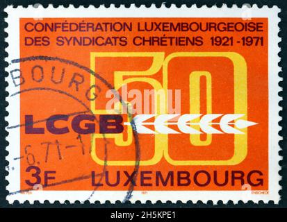 LUSSEMBURGO - CIRCA 1971: Un francobollo stampato in Lussemburgo dedicato all'Unione dei lavoratori Cristiani, 50° anniversario, circa 1971 Foto Stock