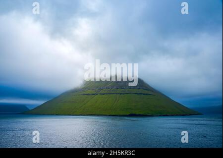 Vista dal traghetto Norrona isola quando si guida attraverso le Isole Faroe, con nuvole tempesta sul paesaggio montano; Isole Faroe, Danimarca Foto Stock