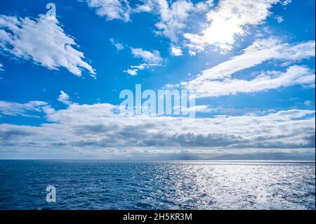 Vista dal traghetto Islanda Norrona quando si avvicina alle Isole Faroe su acque blu oceano e le nuvole nel cielo; Isole Faroe, Danimarca Foto Stock