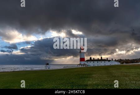 Faro di Souter lungo la costa sotto le nuvole di tempesta ominose; South Shields, Tyne and Wear, Inghilterra Foto Stock