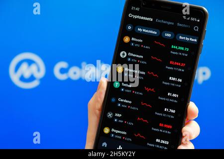 Ucraina, Odessa - Ottobre, 9 2021: Tenere la mano mobile con l'app CoinMarketCap in esecuzione sullo schermo dello smartphone con l'elenco dei prezzi di criptovaluta di oggi, Foto Stock