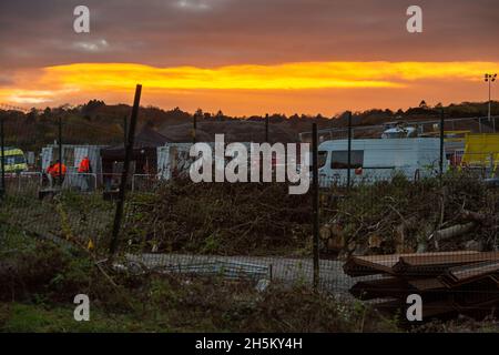 Wendover, Regno Unito. 9 novembre 2021. Il sole tramonta attraverso il composto HS2 Small Dean Lane. Dopo aver distrutto un nappo di nocciole e il bosco medievale di spinney al largo di Small Dean Lane a Wendover, HS2 e stanno ora iniziando lavori di perforazione presso il sito per la loro costruzione di un viadotto attraverso la A413, la linea ferroviaria Chiltern e il piccolo Dean Lane. La gente del posto è furiosa per la distruzione che l'HS2 sta causando al paesaggio. Credit: Maureen McLean/Alamy Foto Stock