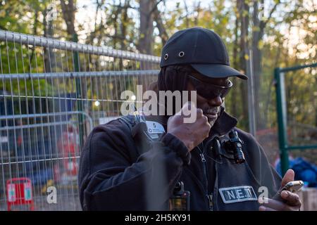 Wendover, Regno Unito. 9 novembre 2021. Il responsabile del National Eviction Team (NET) Enforcement Agent che sta guidando una squadra di baliffi che tenta di sgombrare l'attivista ambientale Swampy e altri tunnellers da sotto il campo DI GUERRA della resistenza attiva di Stop HS2 Wendover. La rete regolarmente film membri della stampa, pubblico e manifestanti a piedi sui sentieri pubblici vicino a siti HS2. La rete ha suturato un certo numero di manifestanti di Stop HS2 e di stampa, ma indossano occhiali scuri anche di notte e coprono il loro volto nel tentativo di non essere riconosciuti. Credit: Maureen McLean/Alamy Foto Stock