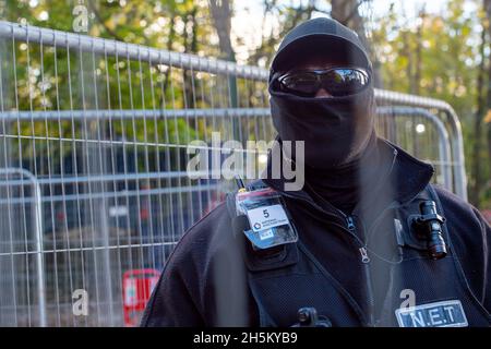 Wendover, Regno Unito. 9 novembre 2021. Il responsabile del National Eviction Team (NET) Enforcement Agent che sta guidando una squadra di baliffi che tenta di sgombrare l'attivista ambientale Swampy e altri tunnellers da sotto il campo DI GUERRA della resistenza attiva di Stop HS2 Wendover. La rete regolarmente film membri della stampa, pubblico e manifestanti a piedi sui sentieri pubblici vicino a siti HS2. La rete ha suturato un certo numero di manifestanti di Stop HS2 e di stampa, ma indossano occhiali scuri anche di notte e coprono il loro volto nel tentativo di non essere riconosciuti. Credit: Maureen McLean/Alamy Foto Stock