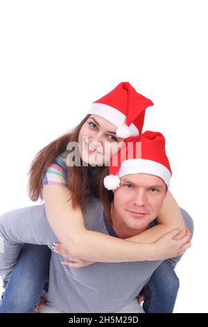 Coppia piuttosto giovane che indossa i cappelli di Babbo Natale Foto Stock