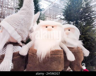 Peluche gnomes di Natale con una barba bianca stand nella lobby del centro commerciale sotto l'albero di Natale Foto Stock