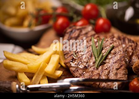 Bistecche alla griglia, patate al forno e verdure da vicino Foto Stock